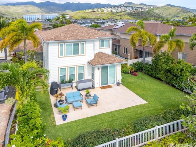 rear view of property featuring a mountain view, a shingled roof, an outdoor hangout area, and a patio