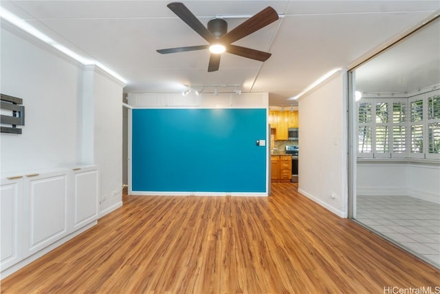 unfurnished living room featuring light wood finished floors, ceiling fan, baseboards, and track lighting