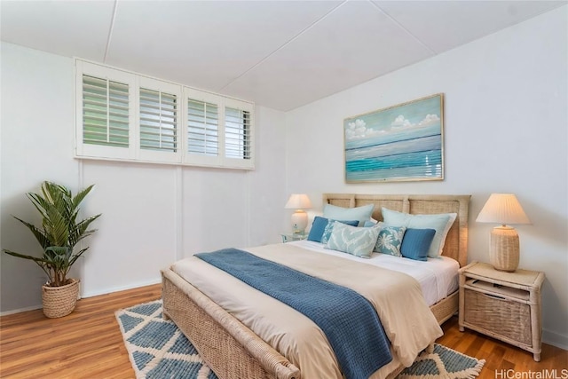 bedroom featuring wood finished floors and baseboards