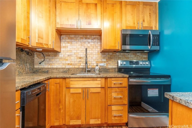 kitchen featuring brown cabinets, decorative backsplash, stainless steel appliances, and a sink