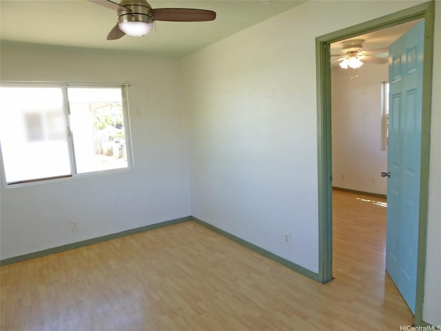 unfurnished room featuring light wood finished floors, baseboards, and a ceiling fan