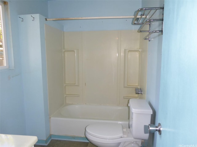 bathroom with bathing tub / shower combination and toilet