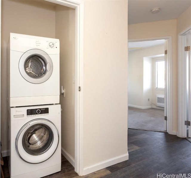 washroom featuring laundry area, baseboards, dark wood finished floors, and stacked washer and clothes dryer