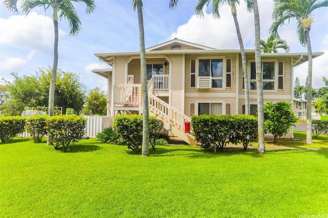 view of front of home featuring fence, a front yard, and stairway