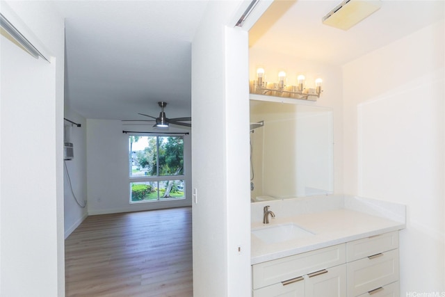 bathroom with vanity, baseboards, a ceiling fan, and wood finished floors