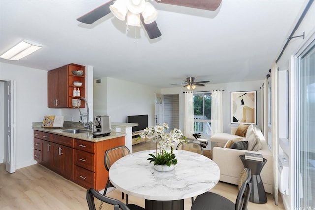 dining room with ceiling fan and light wood-type flooring