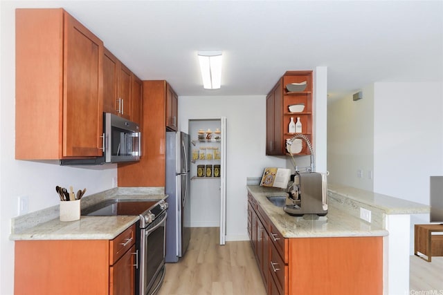 kitchen with open shelves, light stone counters, light wood-style flooring, stainless steel appliances, and a peninsula