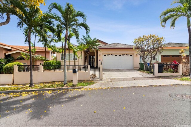 92-1277 Hauone St, Kapolei, HI 96707 - view of front facade featuring a garage, stucco siding, concrete driveway, and a fenced front yard