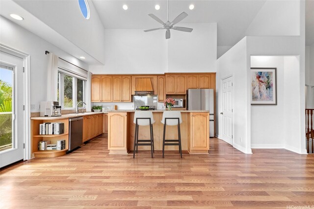 92-1277 Hauone St, Kapolei, HI 96707 - kitchen featuring appliances with stainless steel finishes, high vaulted ceiling, light countertops, a kitchen island, and light wood-style floors