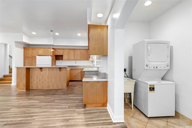 92-1277 Hauone St, Kapolei, HI 96707 - laundry area with stacked washer and clothes dryer, recessed lighting, light wood-style floors, and arched walkways