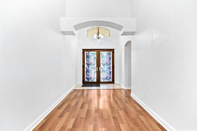 92-1277 Hauone St, Kapolei, HI 96707 - foyer with arched walkways, french doors, light wood-style flooring, and a chandelier