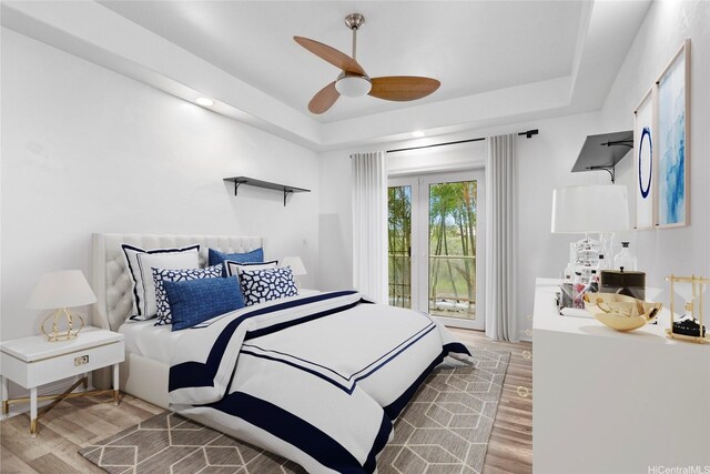 92-1277 Hauone St, Kapolei, HI 96707 - bedroom featuring light wood-style floors, a tray ceiling, and ceiling fan