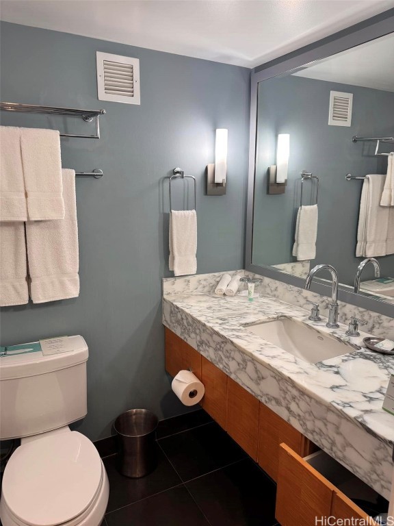 half bathroom with tile patterned flooring, visible vents, a sink, and toilet