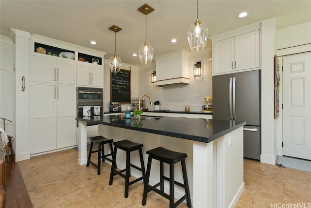 kitchen with dark countertops, backsplash, freestanding refrigerator, white cabinetry, and a sink