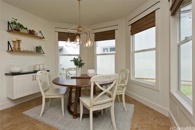 dining area with an inviting chandelier and baseboards