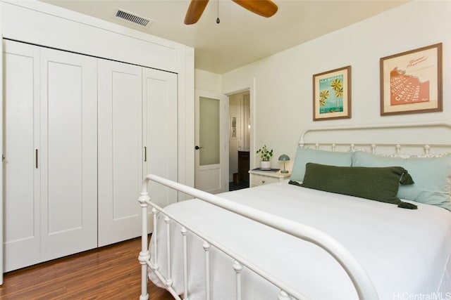 bedroom with ceiling fan, a closet, visible vents, and dark wood-type flooring