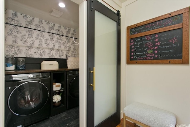 washroom featuring laundry area, a barn door, visible vents, and separate washer and dryer