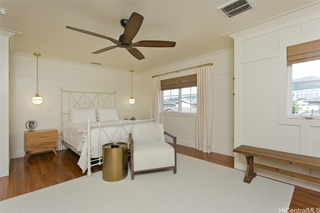 bedroom featuring dark wood finished floors, visible vents, and crown molding