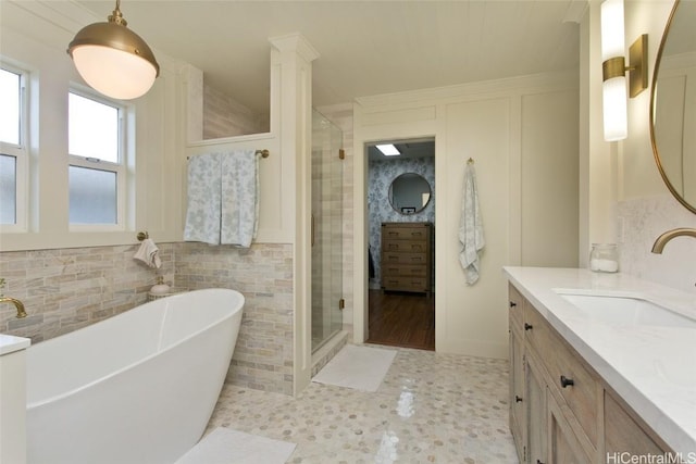 bathroom with tile walls, a soaking tub, a shower stall, and vanity