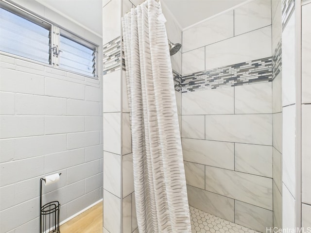 full bath with a tile shower and wood finished floors