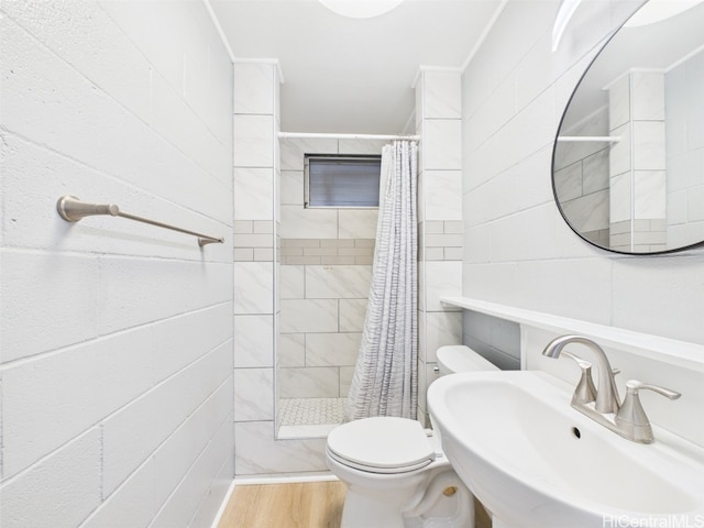 bathroom featuring wood finished floors, a sink, toilet, and a shower stall