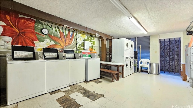 below grade area with separate washer and dryer, a textured ceiling, and stacked washer and clothes dryer
