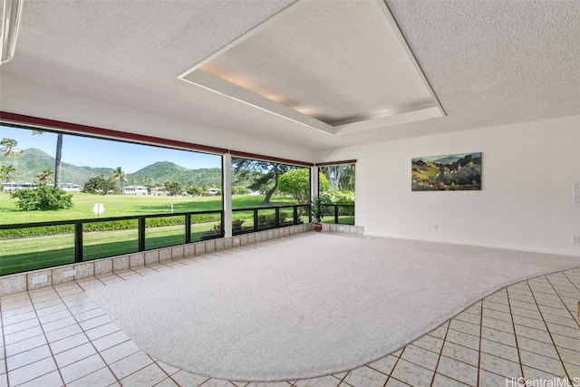 unfurnished sunroom featuring a mountain view and a raised ceiling