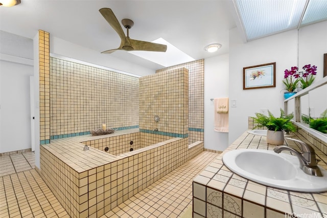 bathroom featuring a ceiling fan, tile patterned floors, a sink, and a bath