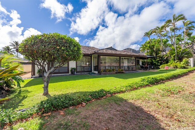 rear view of property featuring a lawn