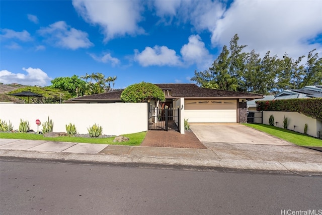 view of front of house with a garage, driveway, a fenced front yard, and a gate