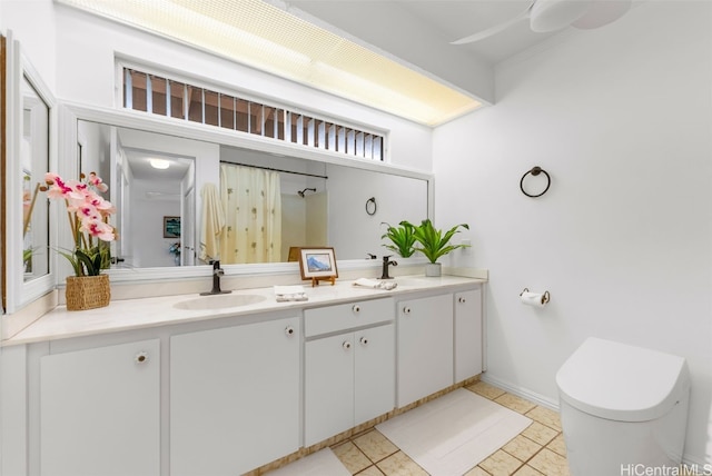 full bath with double vanity, a sink, toilet, and tile patterned floors