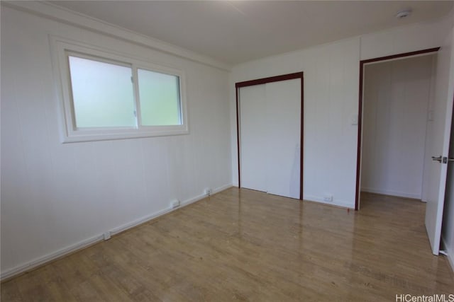 unfurnished bedroom with a closet and light wood finished floors