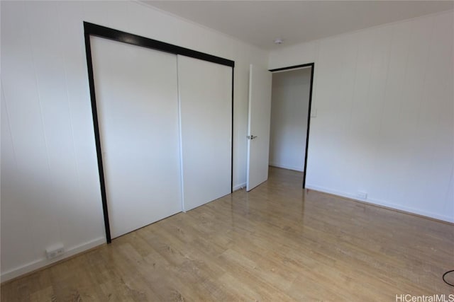 unfurnished bedroom with light wood-type flooring and a closet