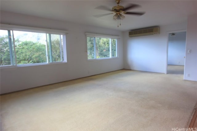 spare room with a wall mounted air conditioner, ceiling fan, and light carpet