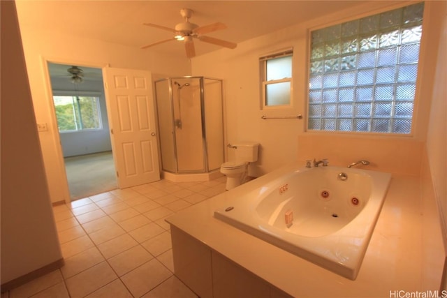 bathroom featuring ceiling fan, tile patterned flooring, toilet, a whirlpool tub, and a stall shower