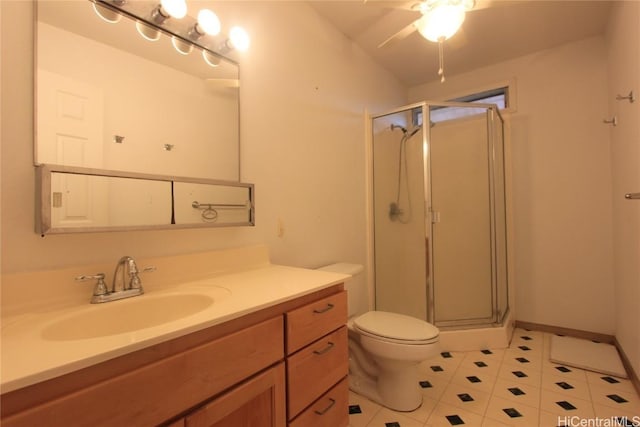 full bathroom with toilet, a stall shower, vanity, and baseboards