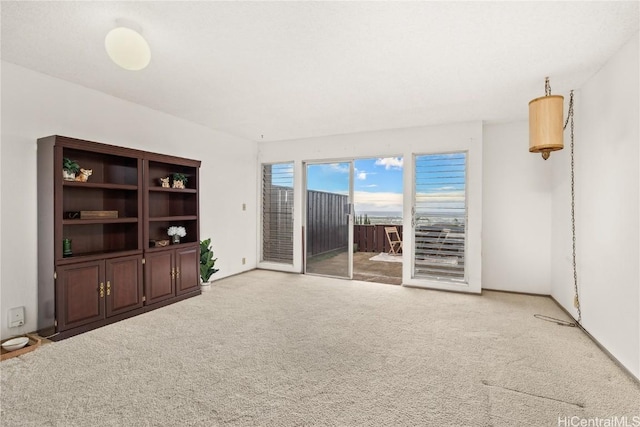 unfurnished living room featuring light colored carpet