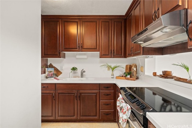 kitchen featuring light countertops, range with electric cooktop, a sink, and under cabinet range hood