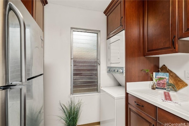 washroom featuring stacked washer and dryer and laundry area