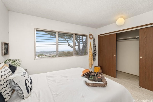 bedroom featuring a textured ceiling, a closet, and carpet flooring