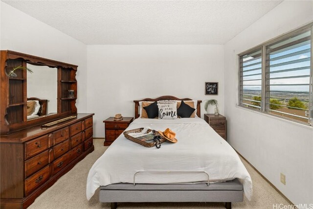 bedroom with light colored carpet and a textured ceiling