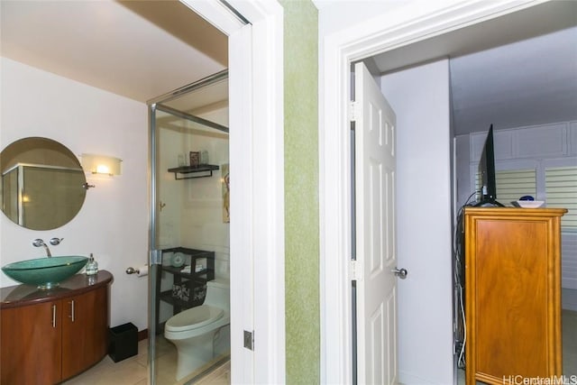 bathroom with a stall shower, vanity, toilet, and tile patterned floors