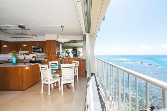 balcony with a water view, a sink, and a beach view