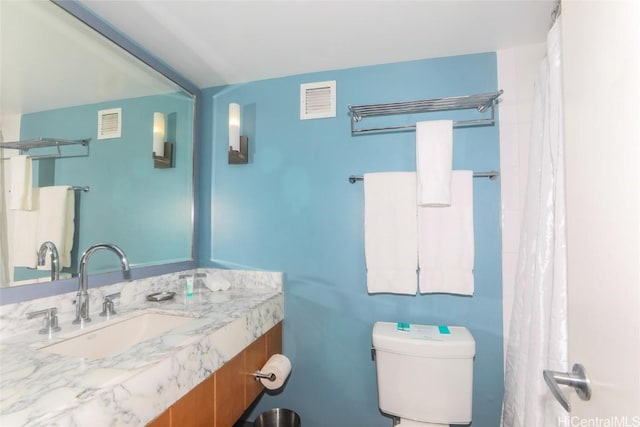 bathroom with visible vents, vanity, and toilet