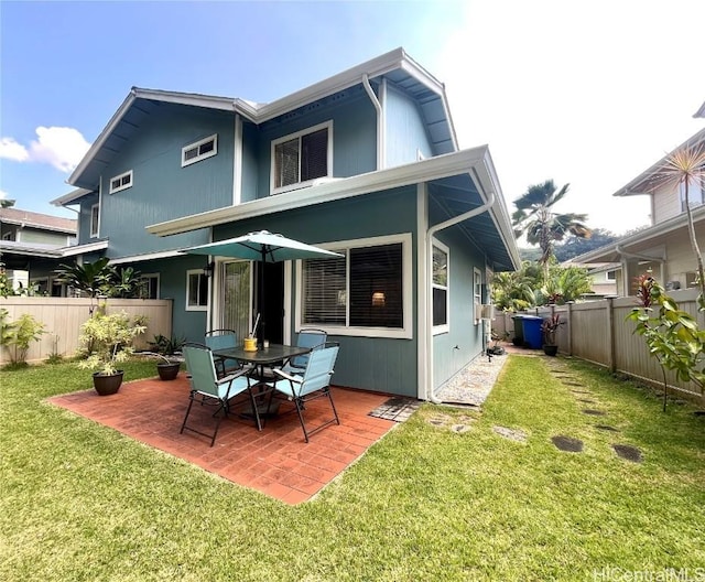 rear view of property with a patio area, a fenced backyard, and a lawn