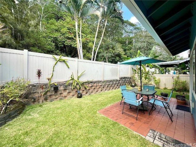 view of yard featuring a patio area, a fenced backyard, and outdoor dining area