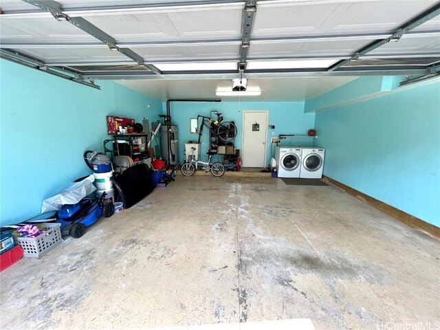 garage featuring water heater, separate washer and dryer, and a garage door opener