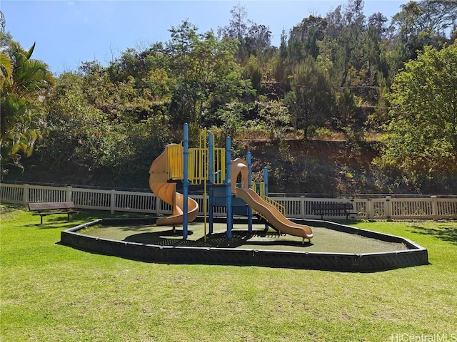 community play area with a lawn and fence