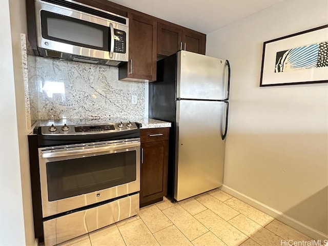 kitchen featuring dark brown cabinetry, tasteful backsplash, light tile patterned floors, and stainless steel appliances