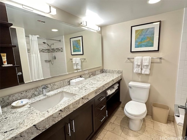 full bath featuring toilet, a tile shower, and vanity